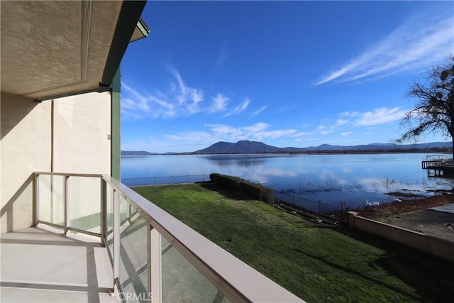 balcony featuring a water and mountain view