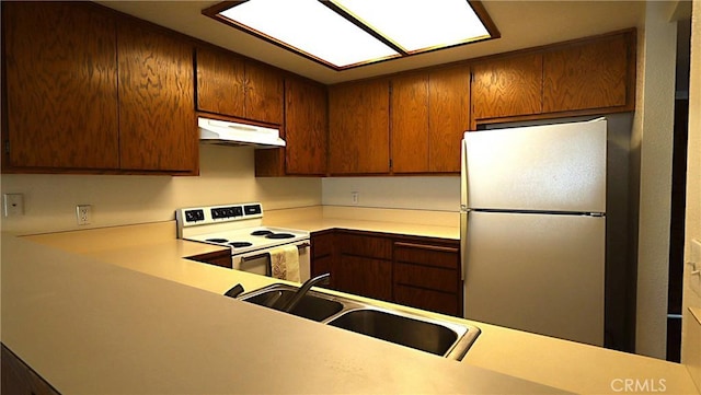 kitchen with electric range, stainless steel fridge, and sink