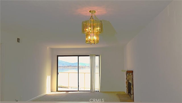 carpeted empty room with a notable chandelier