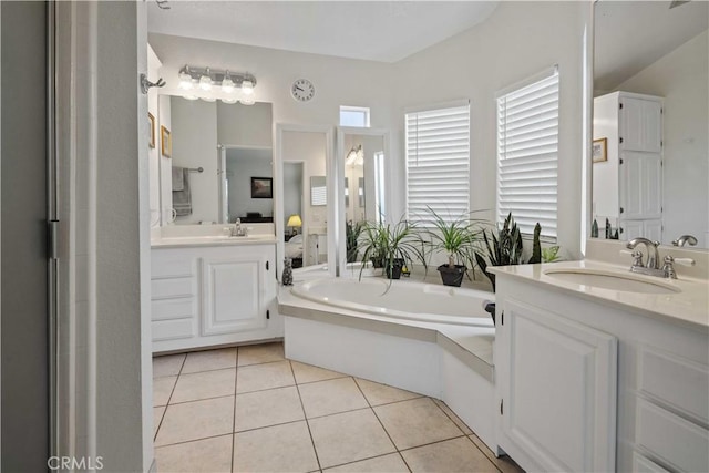 bathroom featuring vanity, tile patterned floors, and a tub