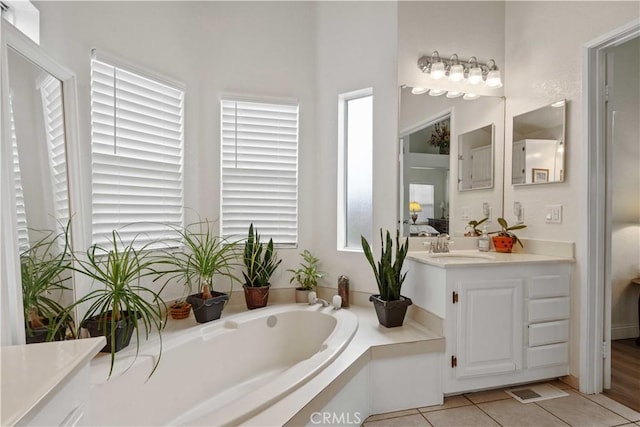 bathroom with a bath, vanity, and tile patterned floors