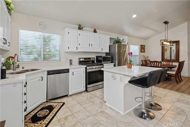 kitchen with pendant lighting, a center island, white cabinets, sink, and stainless steel appliances