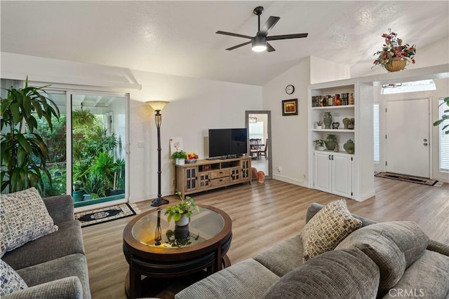 living room with light hardwood / wood-style floors, vaulted ceiling, and ceiling fan