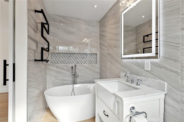 bathroom with vanity, tile walls, and a washtub