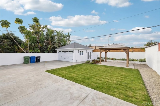 exterior space with a gazebo, a garage, an outbuilding, and a front yard