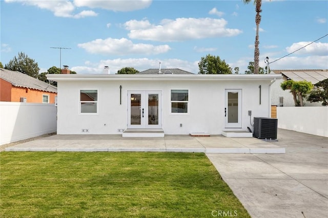 back of property featuring french doors, a lawn, a patio area, and central air condition unit