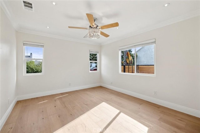 spare room featuring plenty of natural light, light hardwood / wood-style floors, and ornamental molding