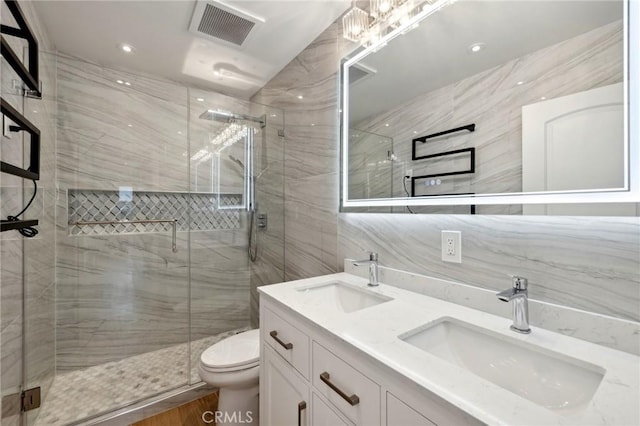 bathroom with vanity, a shower with door, hardwood / wood-style flooring, toilet, and tile walls