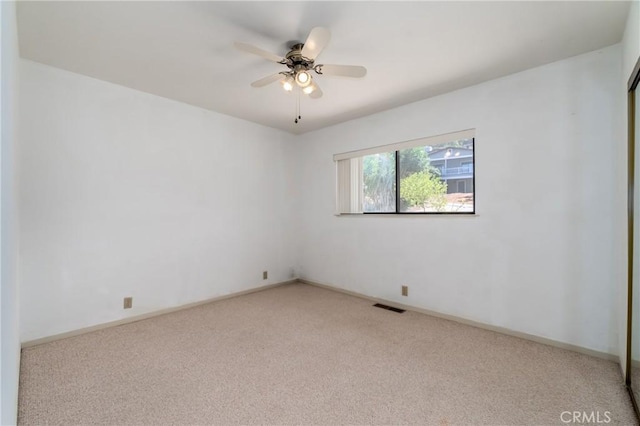 empty room featuring light colored carpet and ceiling fan