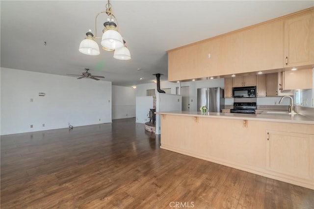 kitchen with kitchen peninsula, light brown cabinetry, dark hardwood / wood-style flooring, and black appliances