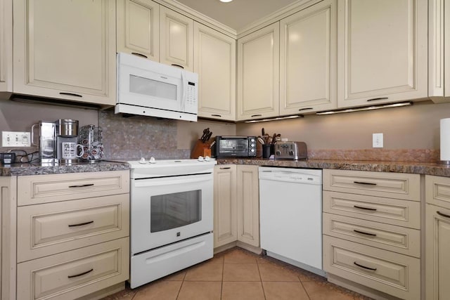 kitchen featuring white appliances, cream cabinets, and light tile patterned floors