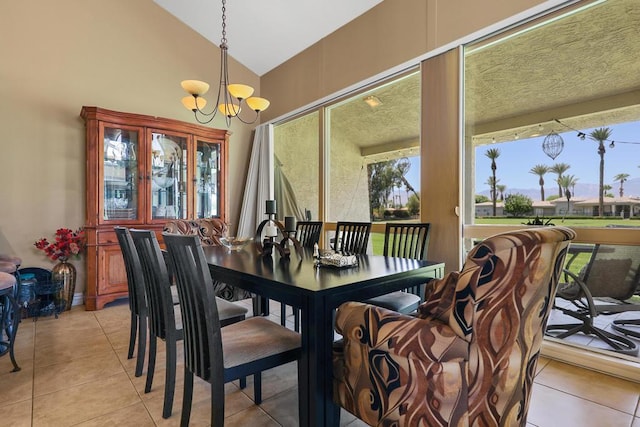 dining area featuring lofted ceiling, a chandelier, and light tile patterned flooring