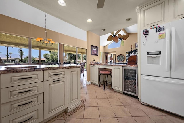 kitchen featuring wine cooler, light tile patterned flooring, lofted ceiling, hanging light fixtures, and white refrigerator with ice dispenser