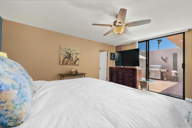 bedroom featuring ceiling fan and a wall of windows