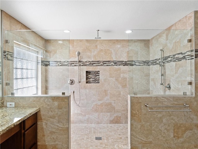 bathroom featuring a tile shower and vanity