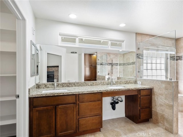 bathroom with a tile shower, tile patterned floors, and vanity