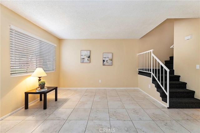 interior space featuring light tile patterned floors and a textured ceiling