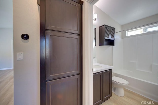 full bathroom featuring shower / bathing tub combination, vanity, lofted ceiling, toilet, and wood-type flooring