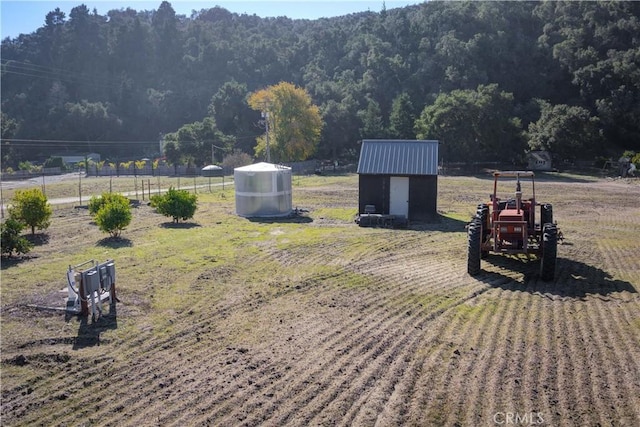 view of home's community with a rural view and a shed