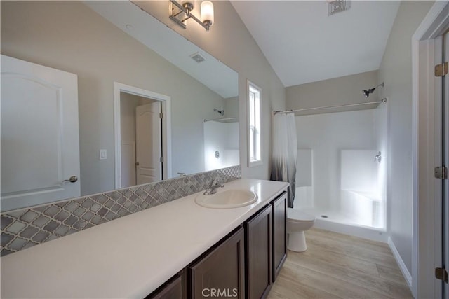 bathroom with a shower with curtain, vanity, hardwood / wood-style floors, toilet, and lofted ceiling