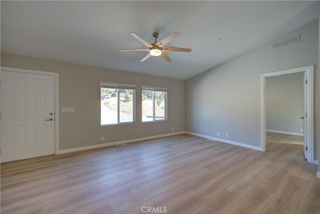 empty room featuring vaulted ceiling, light hardwood / wood-style flooring, and ceiling fan