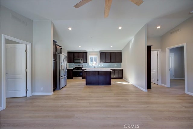 1592 Deer Canyon Rd, Arroyo Grande, CA 93420 - kitchen with appliances with stainless steel finishes, a ceiling fan, dark brown cabinetry, a center island, and light countertops