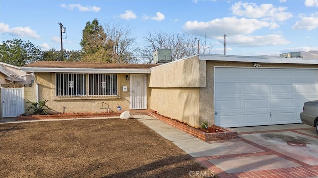 single story home with a garage and central AC unit