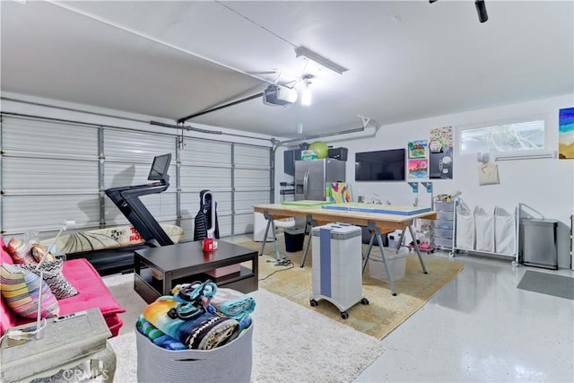 garage with stainless steel fridge and a garage door opener