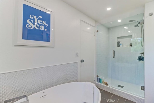 bathroom with independent shower and bath and tile patterned flooring