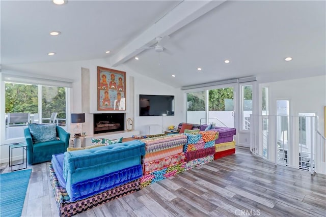 living room featuring ceiling fan, light hardwood / wood-style flooring, and lofted ceiling with beams