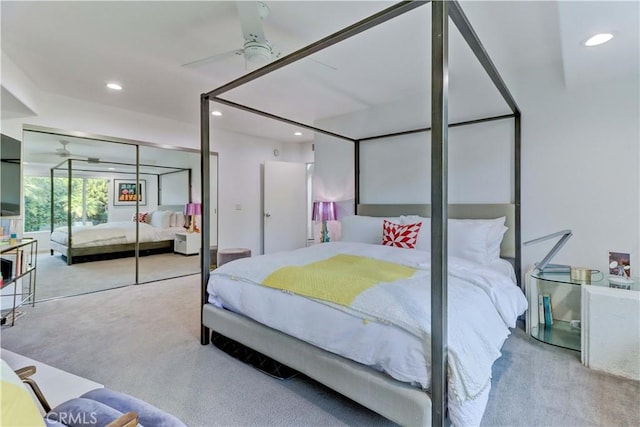 bedroom with ceiling fan, light colored carpet, and a closet