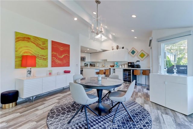 dining area with wine cooler, lofted ceiling with beams, light wood-type flooring, and a chandelier