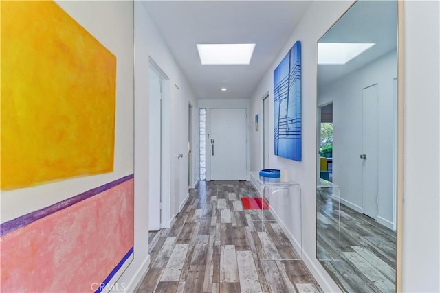 corridor featuring a skylight and hardwood / wood-style floors