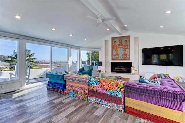 living room featuring ceiling fan, vaulted ceiling with beams, and hardwood / wood-style flooring