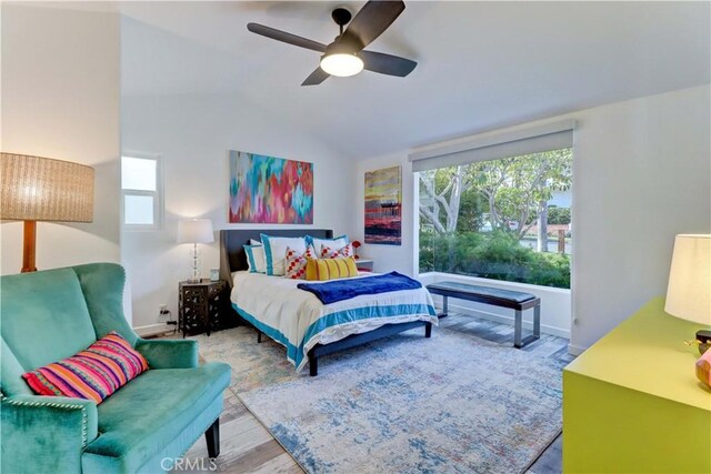 bedroom featuring ceiling fan, lofted ceiling, and light hardwood / wood-style floors