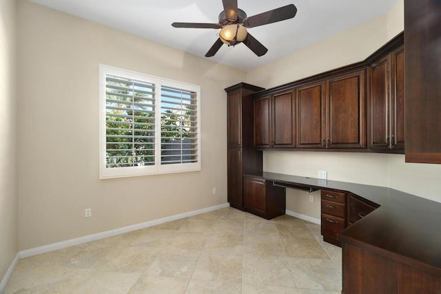 unfurnished office with ceiling fan and built in desk