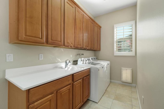 laundry area featuring sink, washing machine and clothes dryer, and cabinets