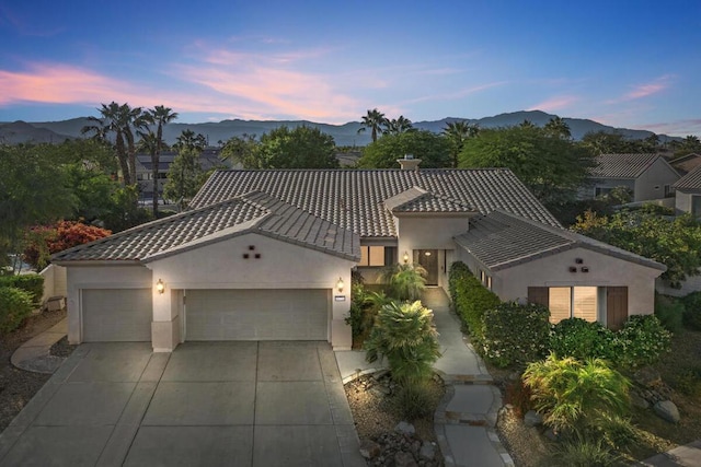 mediterranean / spanish house featuring a garage and a mountain view