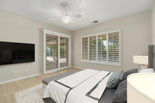 bedroom featuring ceiling fan, light wood-type flooring, and multiple windows