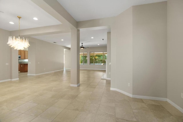 tiled spare room featuring ceiling fan with notable chandelier