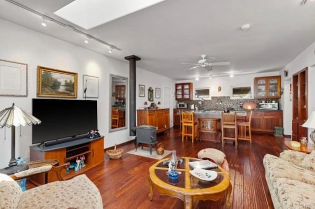 living room featuring ceiling fan, dark hardwood / wood-style flooring, track lighting, and a skylight