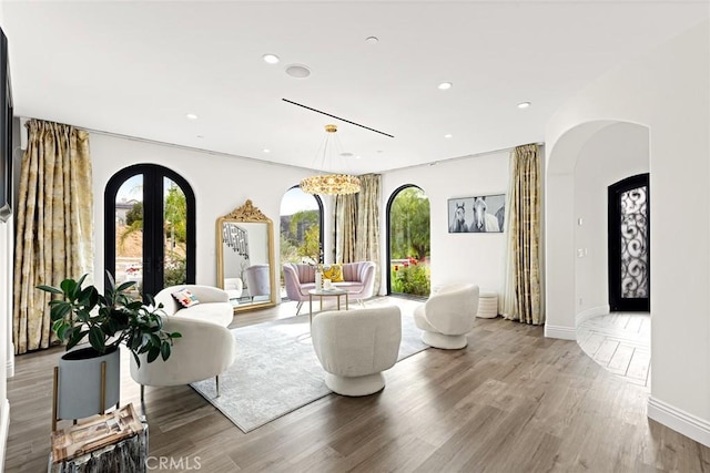 living room featuring a chandelier, french doors, and hardwood / wood-style flooring