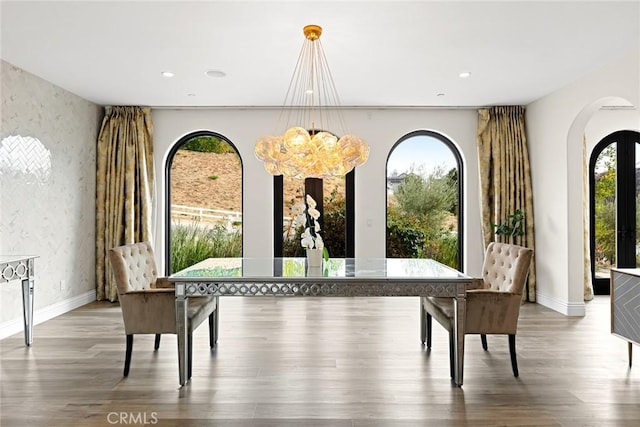 dining area featuring hardwood / wood-style flooring and a notable chandelier