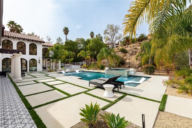 view of pool with an in ground hot tub, pool water feature, and a patio area