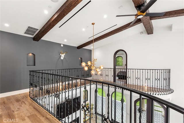 hall featuring lofted ceiling with beams, light hardwood / wood-style floors, and an inviting chandelier