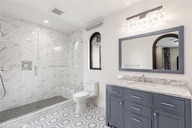 bathroom with vanity, toilet, and a shower with door