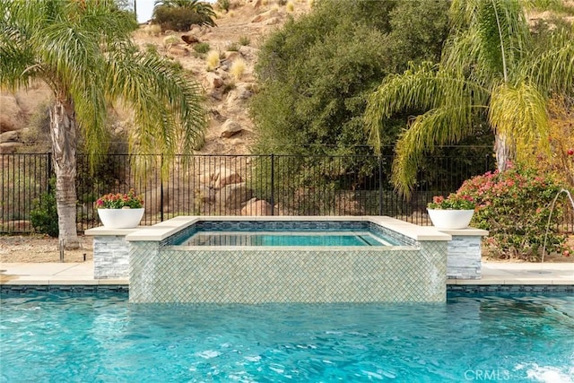 view of swimming pool with a hot tub