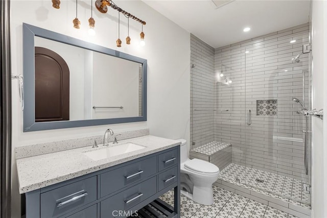 bathroom featuring vanity, an enclosed shower, and toilet