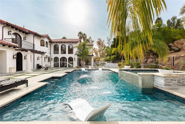 view of pool with an in ground hot tub, pool water feature, and a patio area