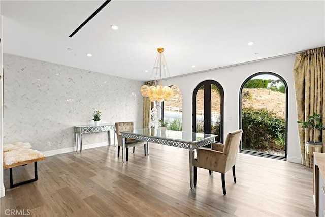 dining area with a chandelier, light wood-type flooring, and ornamental molding